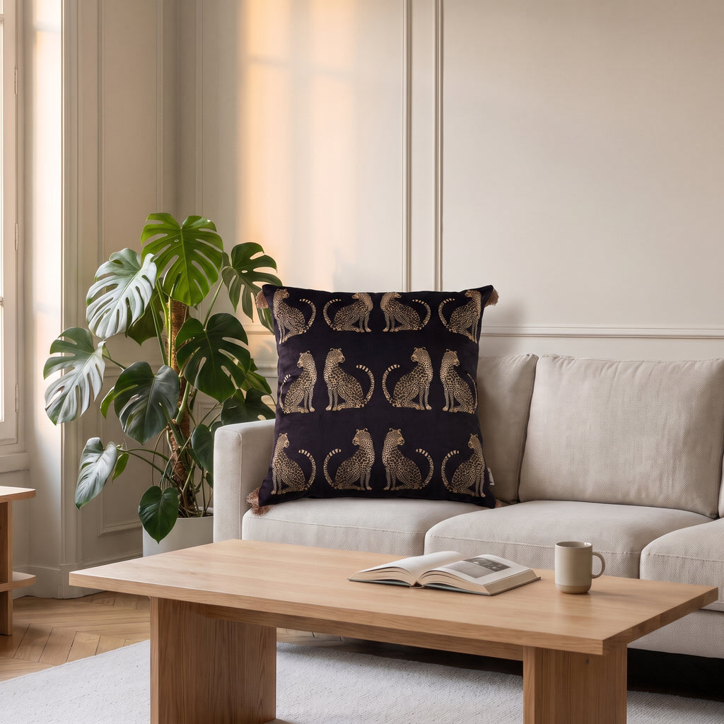 Housse de coussin léopard noire posée sur un canapé de salon
