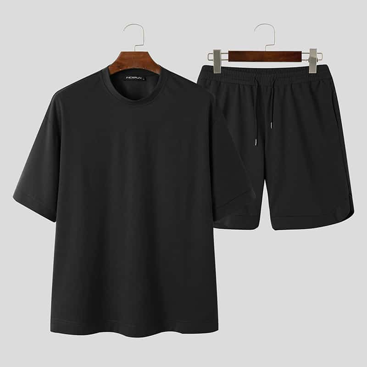 T-shirt et short noirs présentés ensemble sur cintres