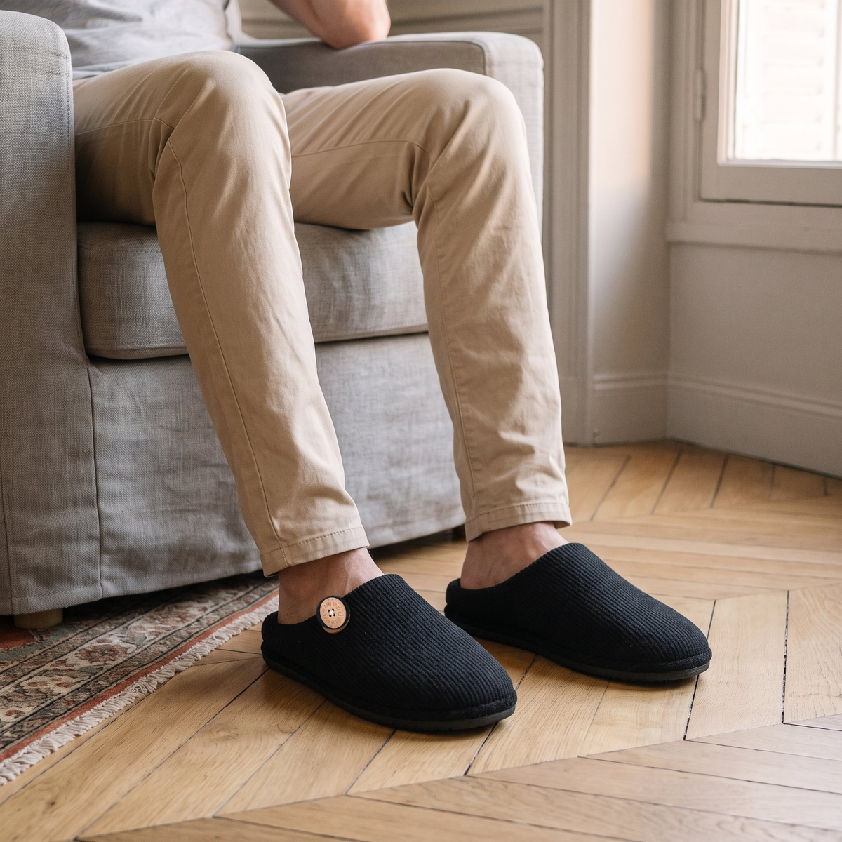 Chaussons homme noir portés dans le salon
