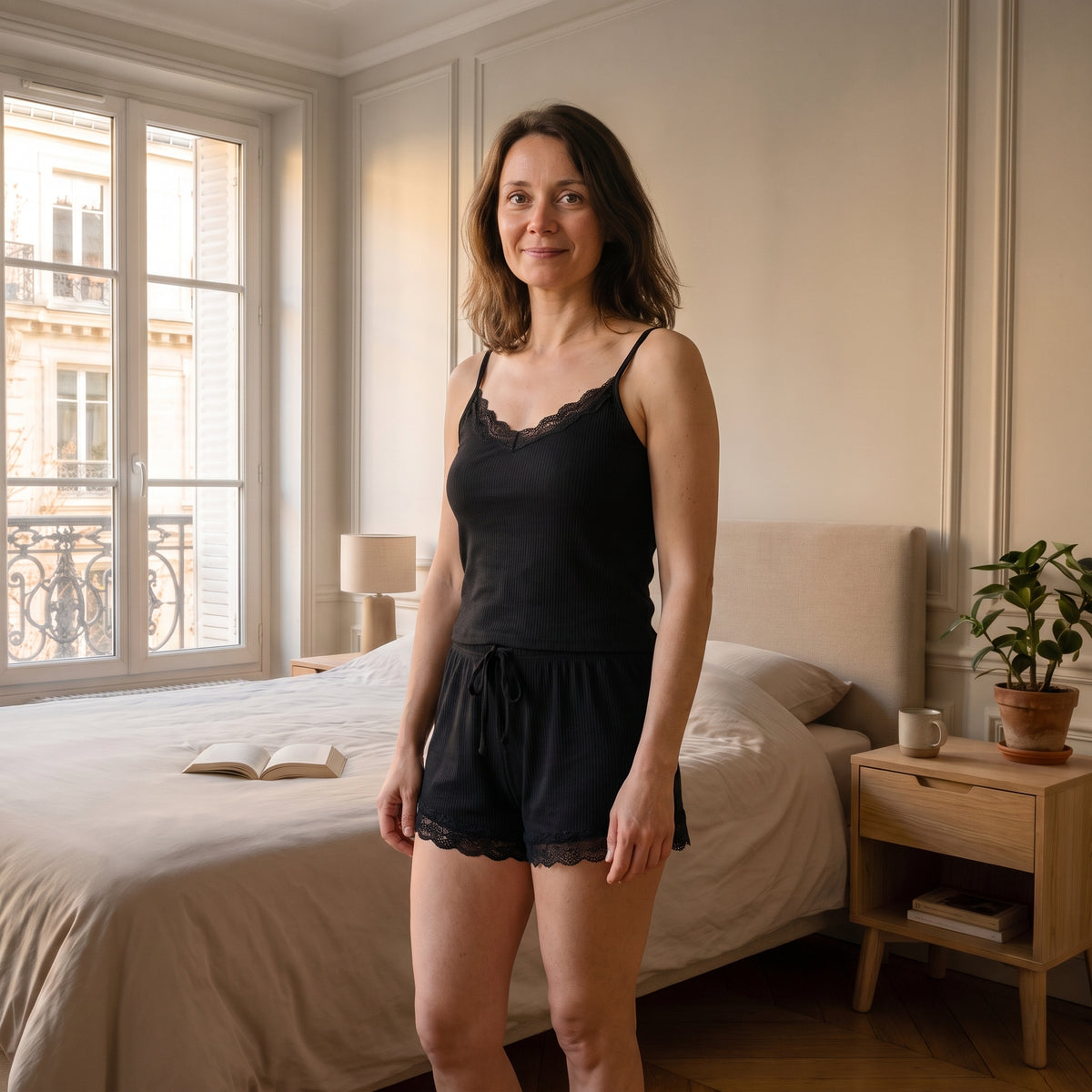 Femme du casting portant le pyjama court noir en coton côtelé dans une chambre lumineuse