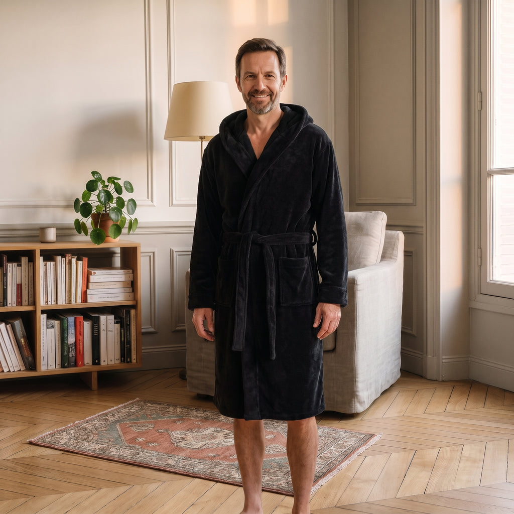 Homme du casting portant la robe de chambre Noire à capuche dans le coin lecture