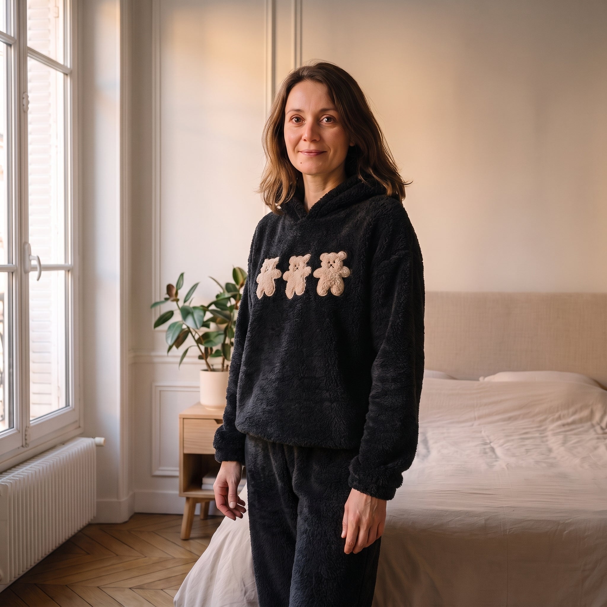 Femme portant le pyjama d'hiver noir trois ours dans une chambre lumineuse Image