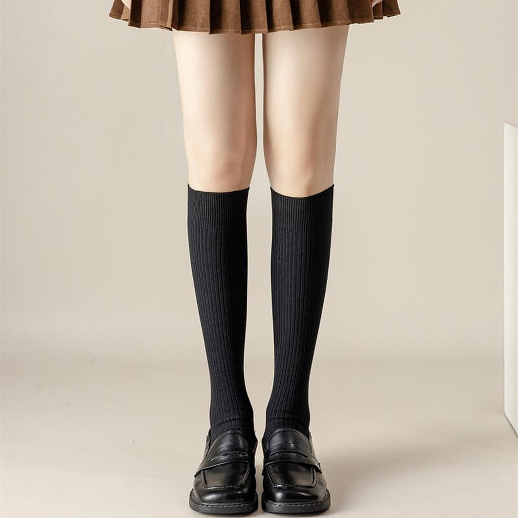 Chaussettes hautes noires portees sous le genou avec des mocassins