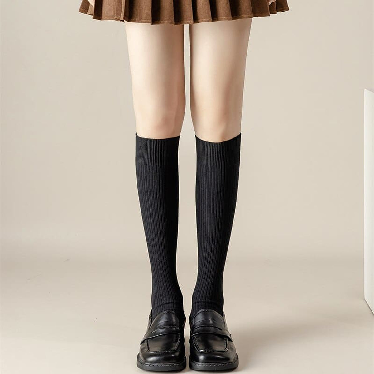 Chaussettes hautes noires portees sous le genou avec des mocassins