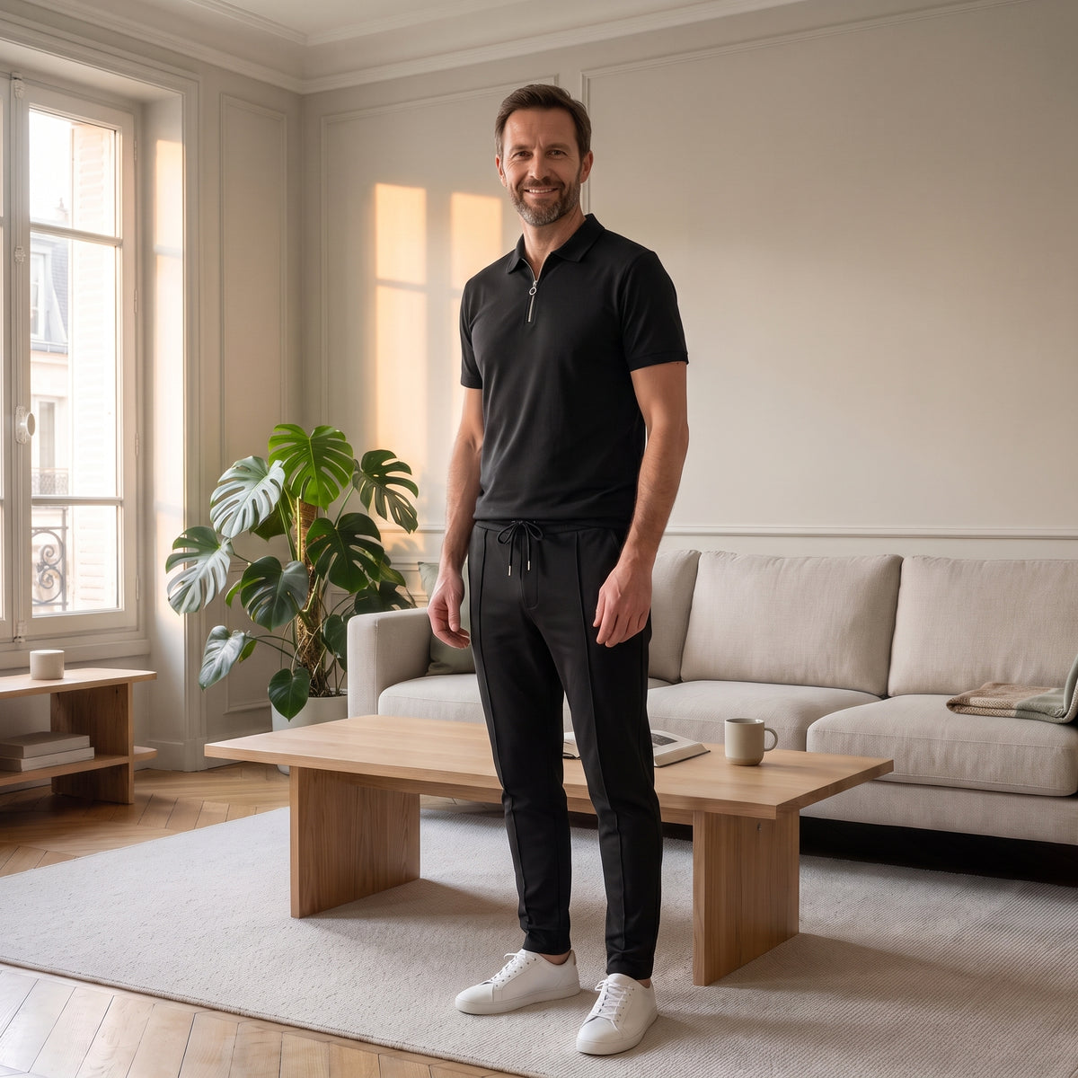 Homme en ensemble polo et pantalon noir dans un salon parisien