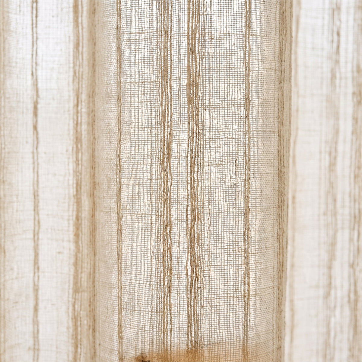 Gros plan sur le tissage et les rayures brodées du rideau beige effet lin Image