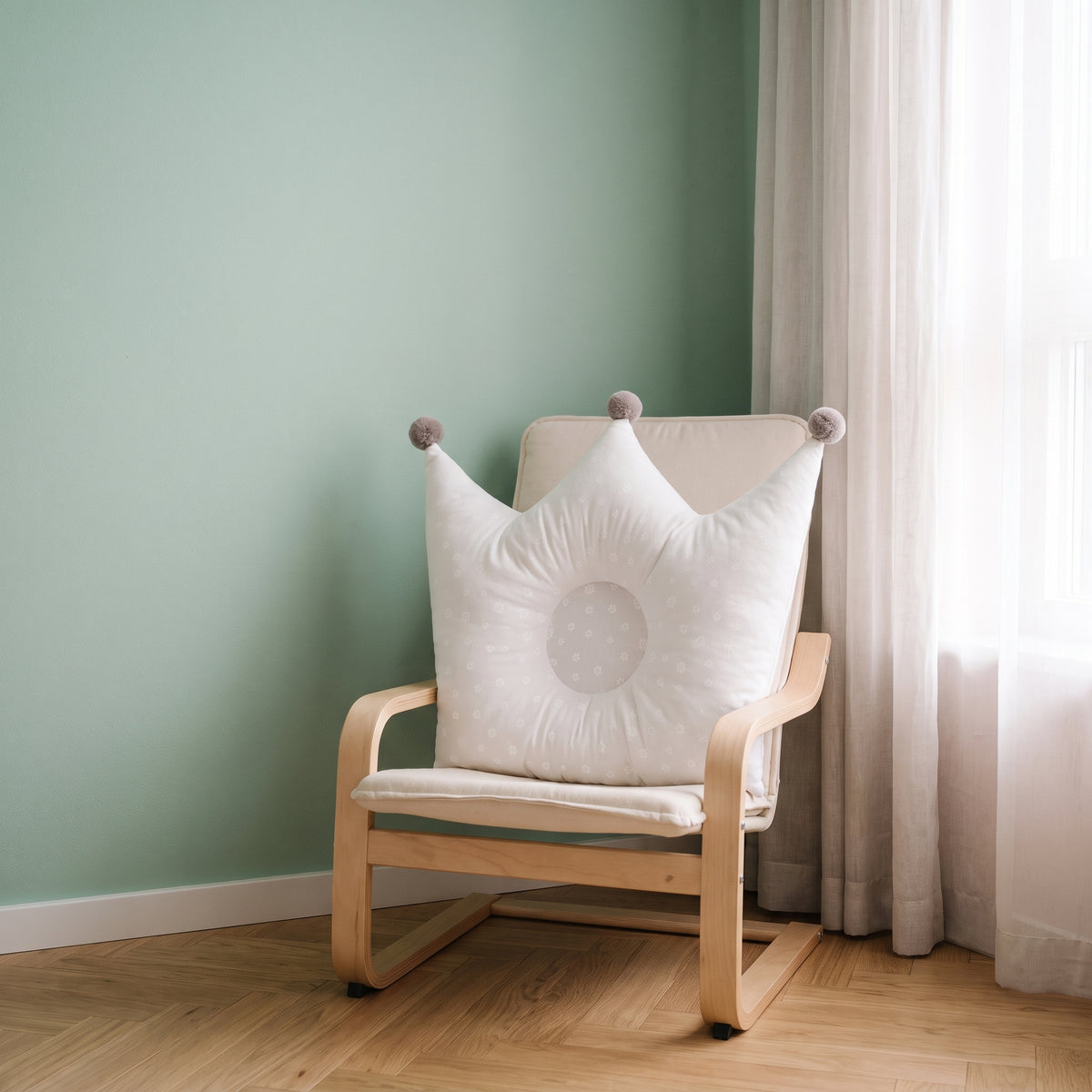 Oreiller couronne blanc à petits motifs floraux clairs sur un fauteuil d’enfant