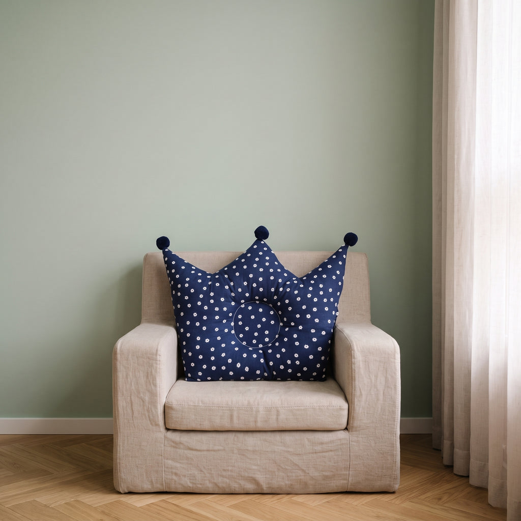 Oreiller couronne bleu marine pour bébé sur un fauteuil d’enfant