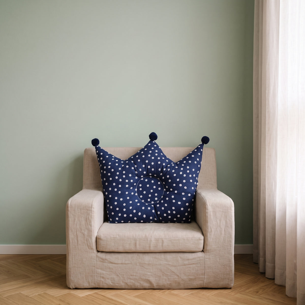 Oreiller couronne bleu marine pour bébé sur un fauteuil d’enfant