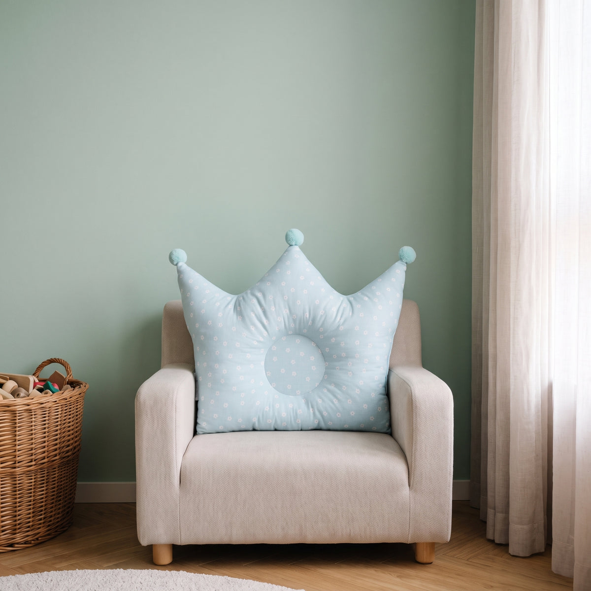 Oreiller couronne bleu clair pour bébé sur un fauteuil d’enfant