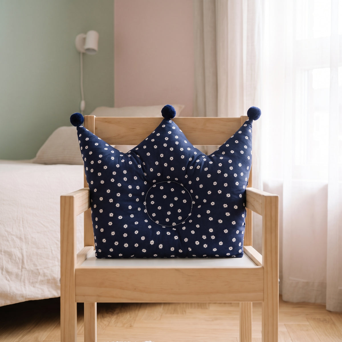 Détail de l’oreiller couronne bleu marine sur un fauteuil d’enfant Image