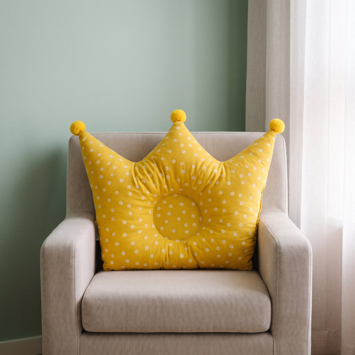 Oreiller couronne jaune pour bébé sur un fauteuil d’enfant