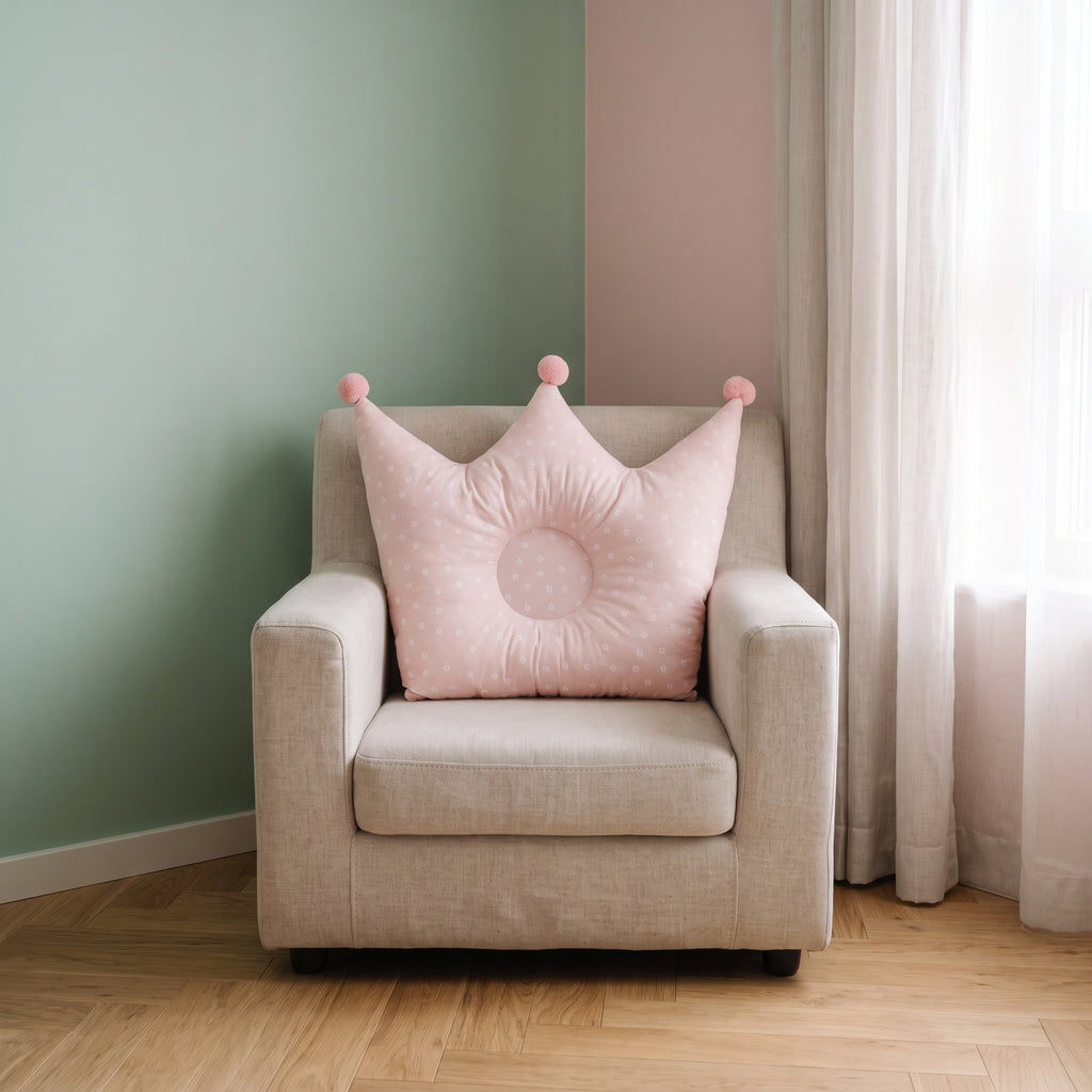 Oreiller couronne rose pour bébé sur un fauteuil d’enfant