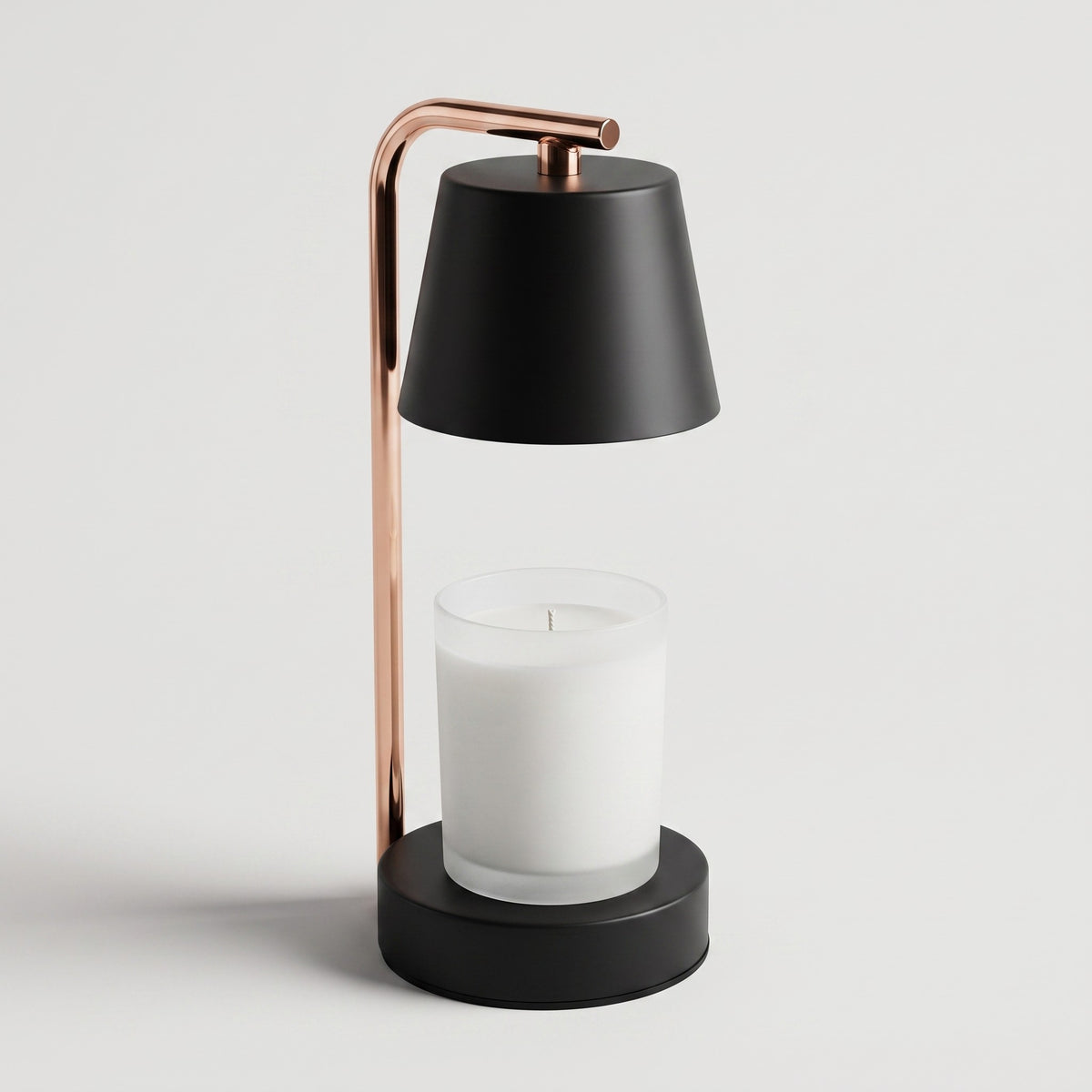 Lampe chauffe-bougie noire vue de face sur fond clair, un pot de bougie en verre posé au centre de son socle
