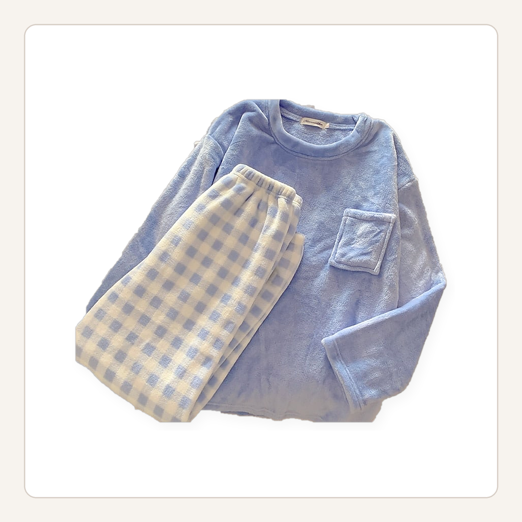 Ensemble de pyjama en flanelle bleu posé à plat, haut uni à poche et bas à carreaux.