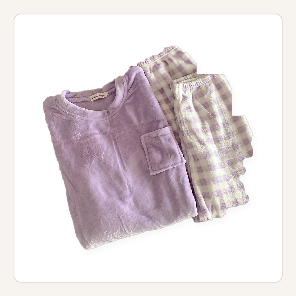 Ensemble de pyjama en flanelle violet posé à plat, haut uni à poche et bas à carreaux.