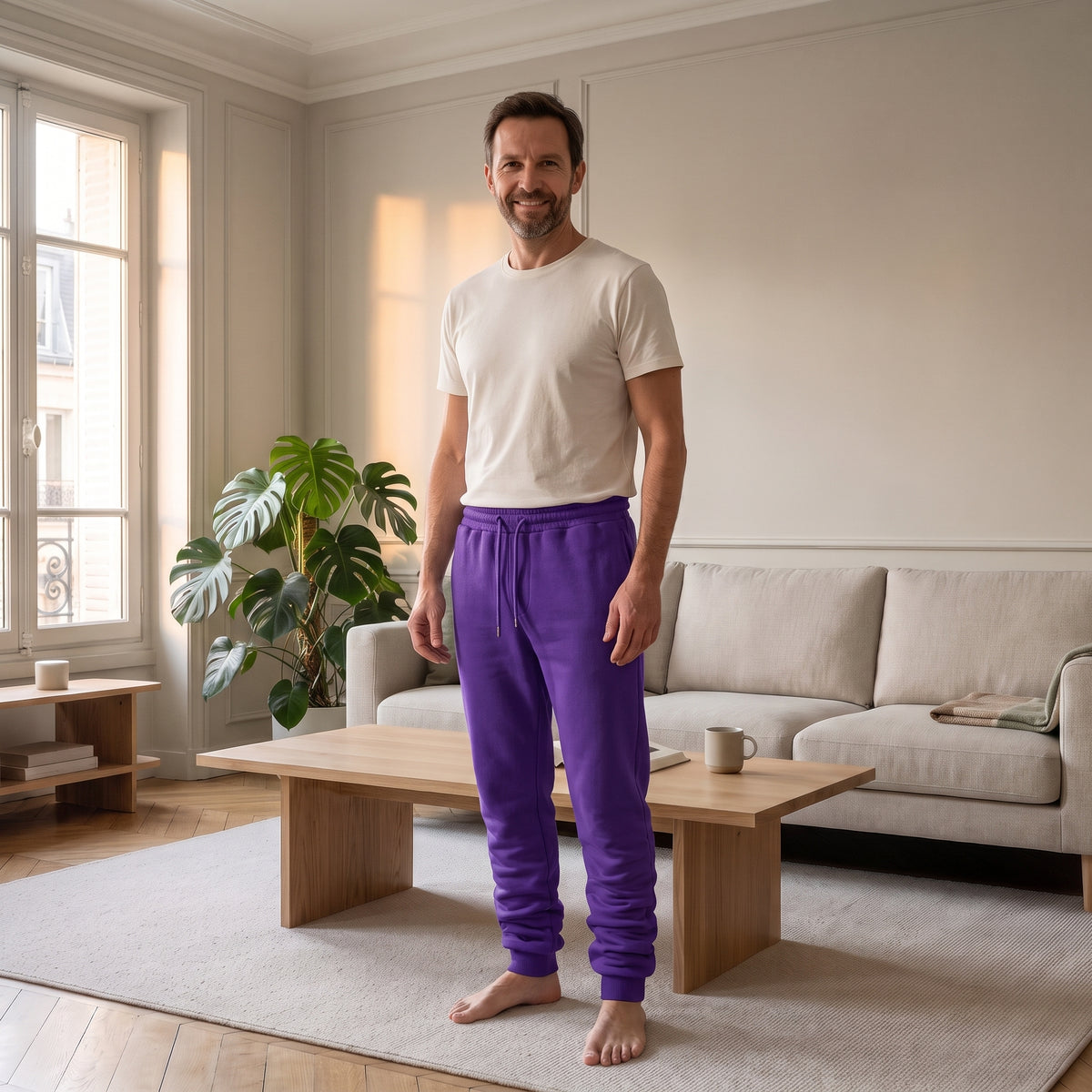 Homme portant le pantalon de jogging violet dans un salon lumineux