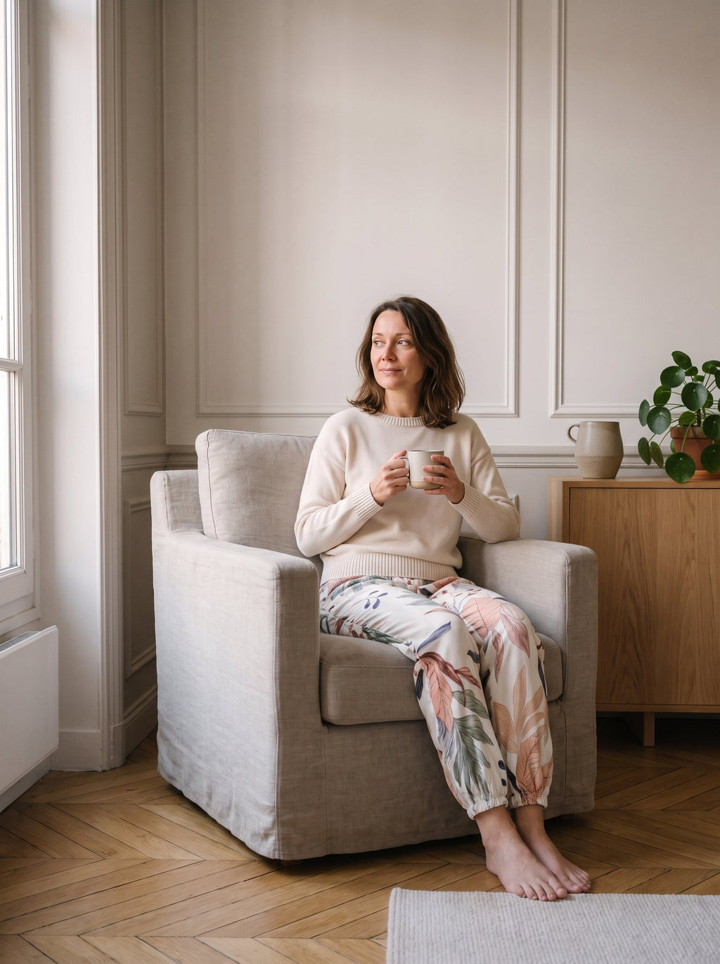 Pantalon cocooning femme ivoire à feuillage corail dans un fauteuil