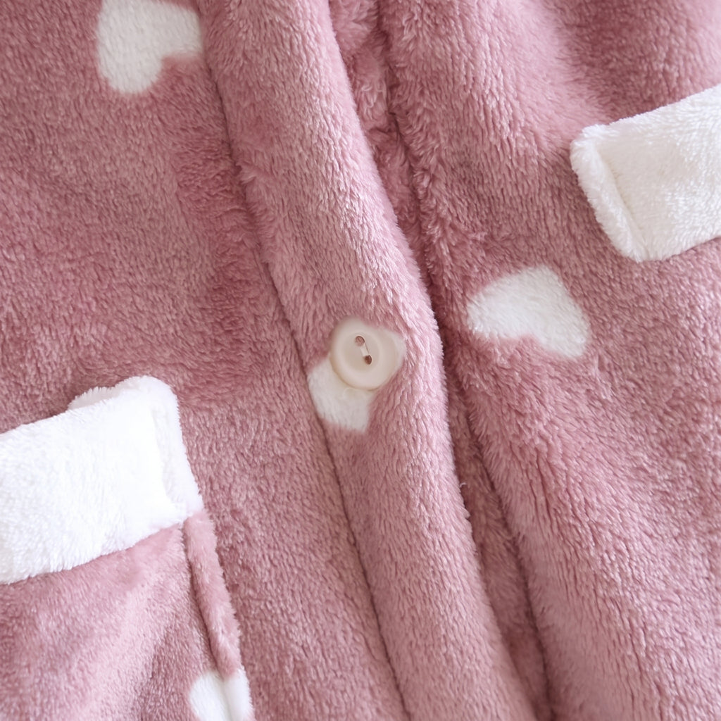 Détail du peignoir polaire rose à cœurs avec bouton et bordure de poche