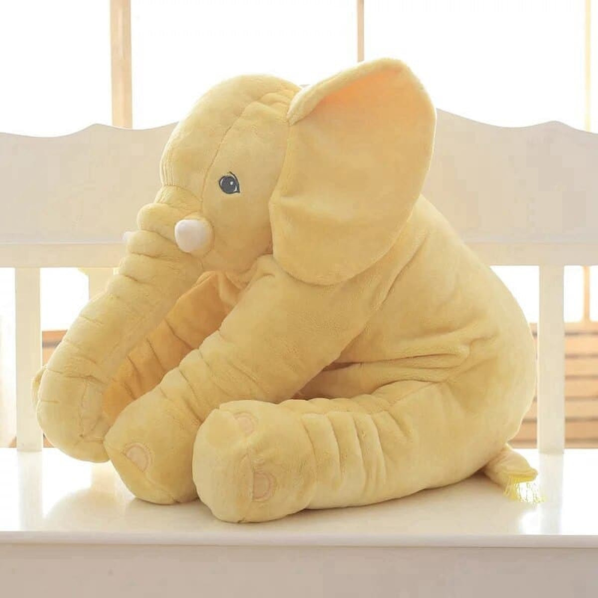 Peluche éléphant jaune assise vue de trois quarts