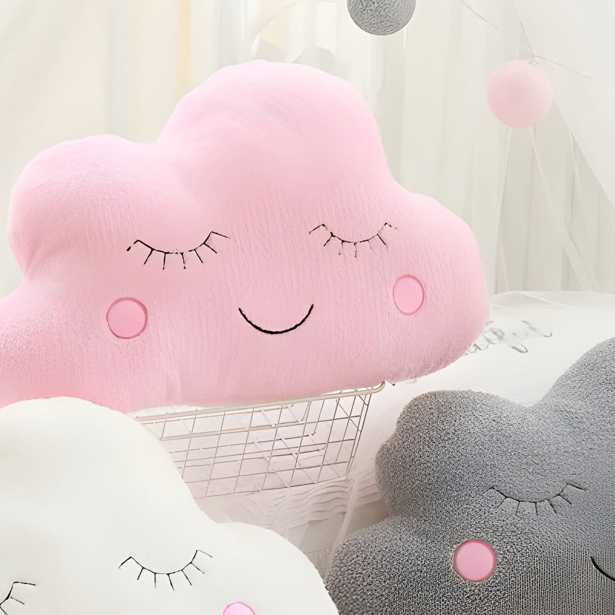 Détail rapproché de la peluche nuage rose avec surface textile, cils, sourire et pommettes