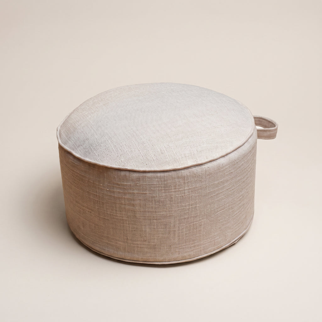 Packshot du coussin de sol rond beige avec poignée latérale visible