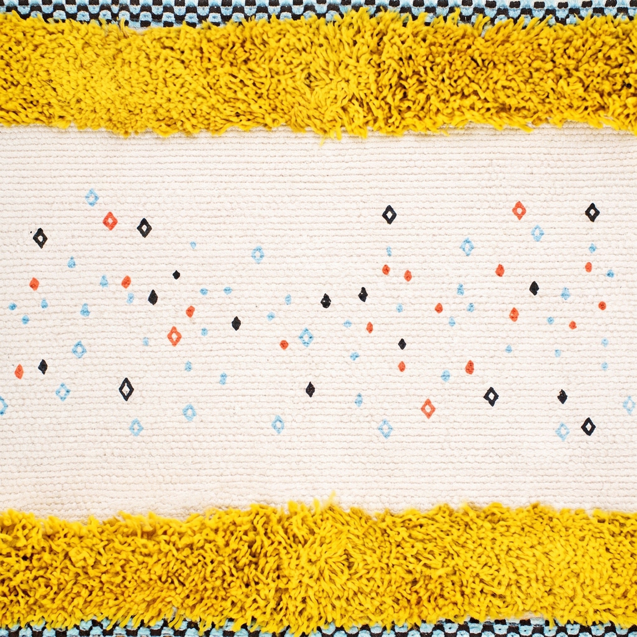 Losanges et points corail, bleu ciel et noirs tissés dans la trame ivoire, entre deux bandes touffetées jaune moutarde Image