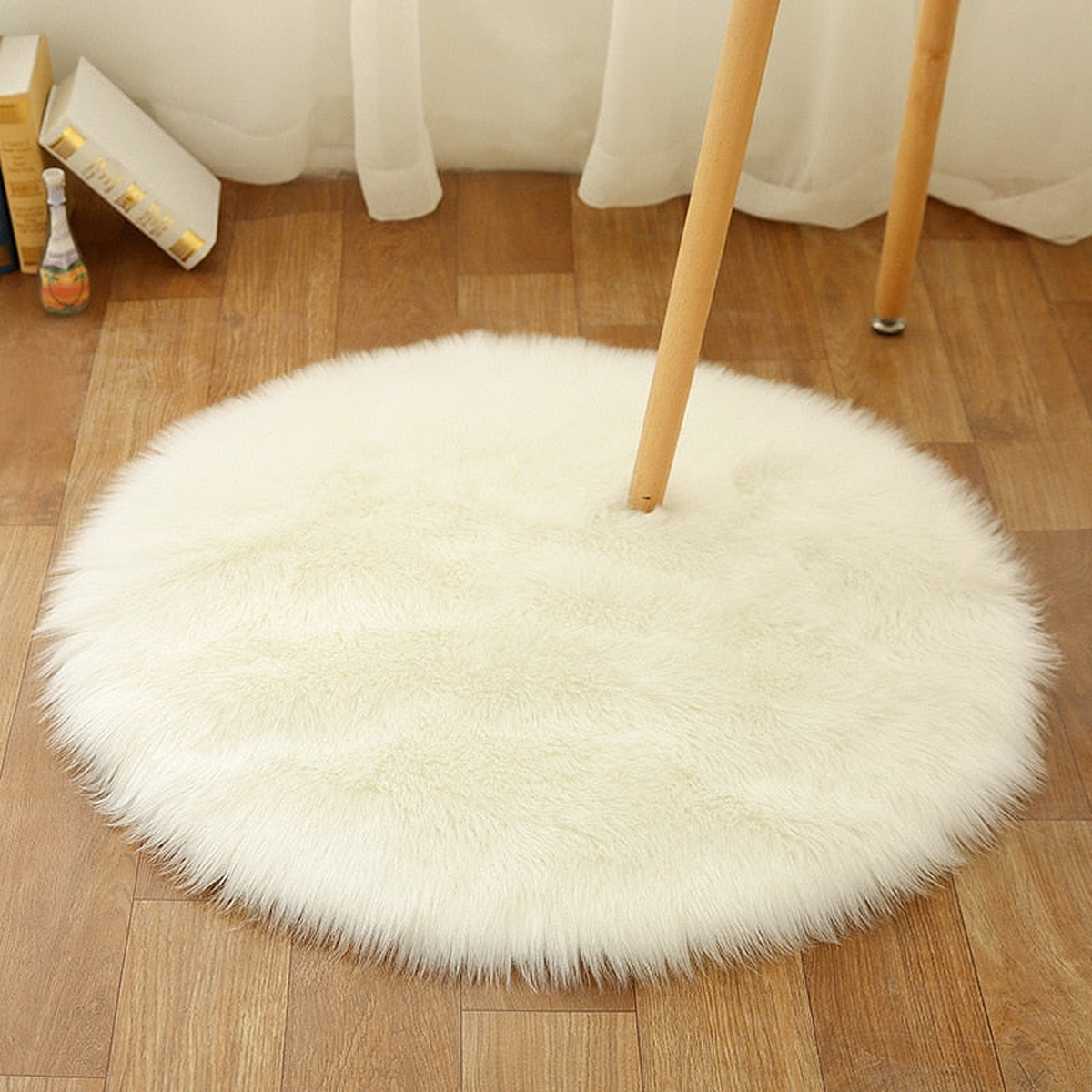Petit tapis rond blanc en petit format sous une chaise