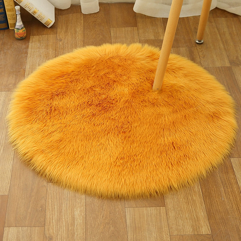 Petit tapis rond orange en petit format sous une chaise
