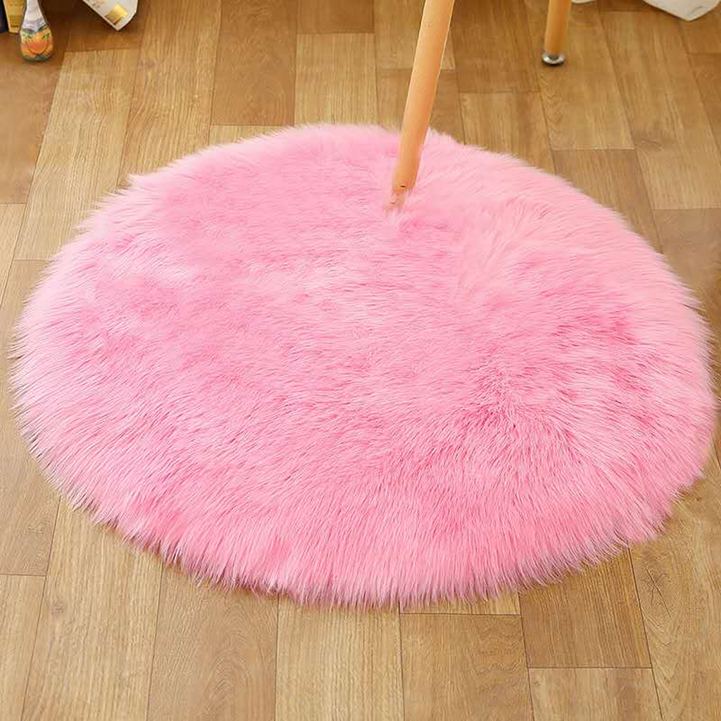Petit tapis rond rose en petit format sous une chaise