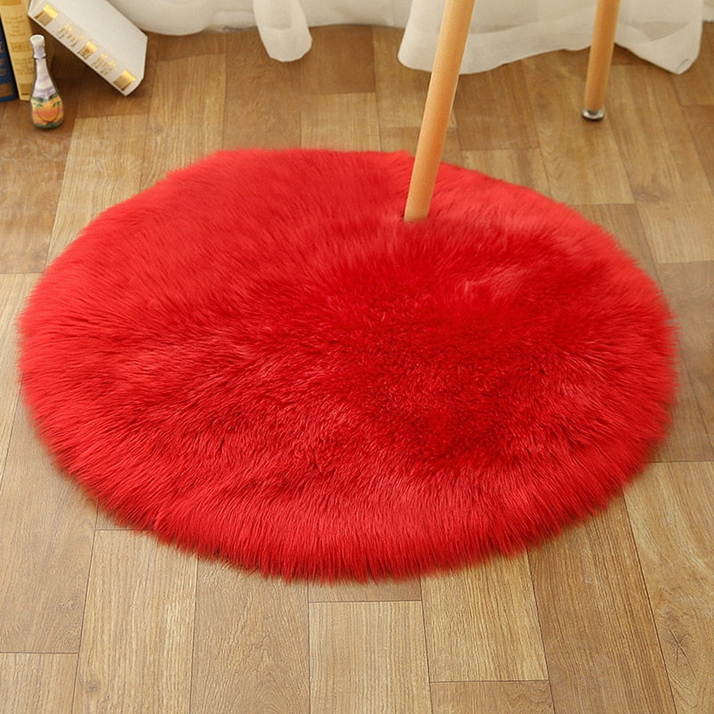 Petit tapis rond rouge en petit format sous une chaise