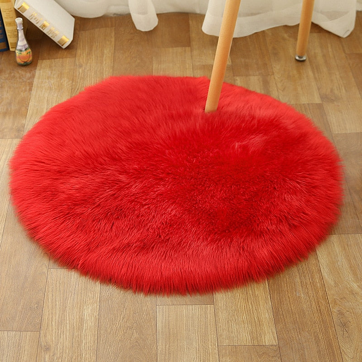 Petit tapis rond rouge en petit format sous une chaise