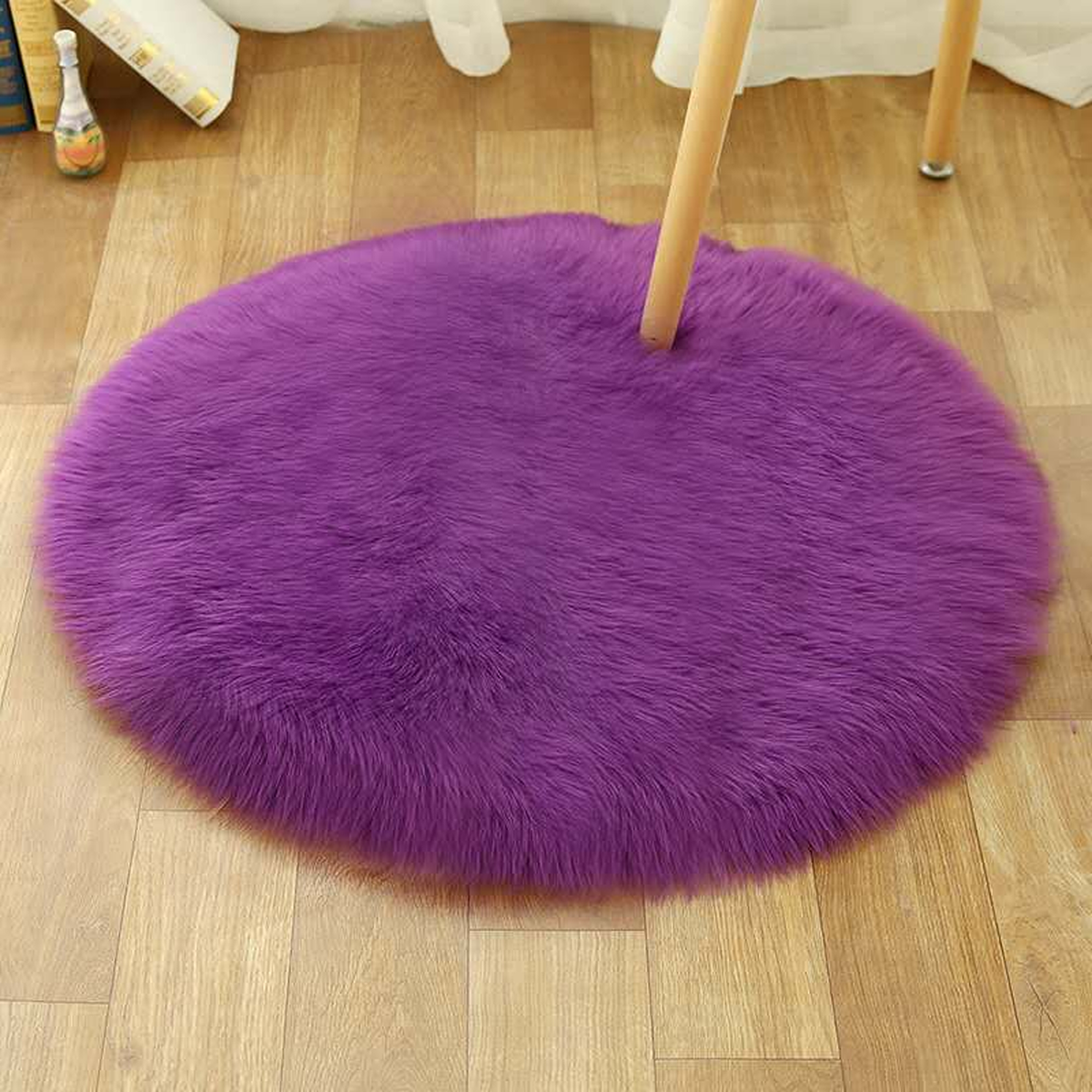 Petit tapis rond violet en petit format sous une chaise