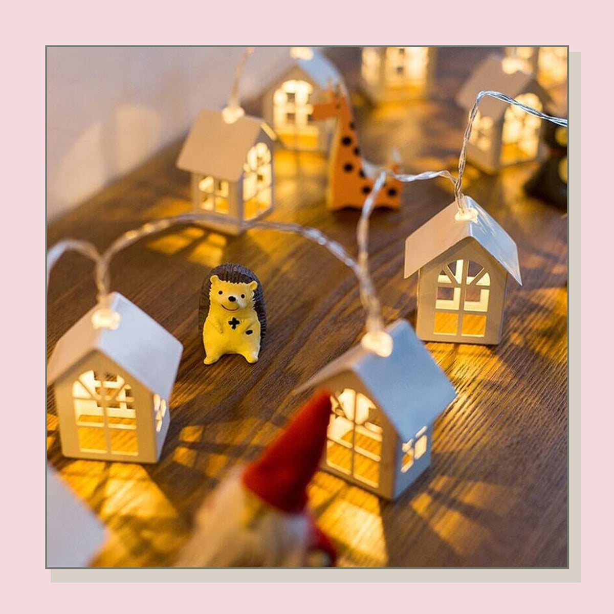 Petite guirlande lumineuse de Noël autour de maisons décoratives sur une table Image