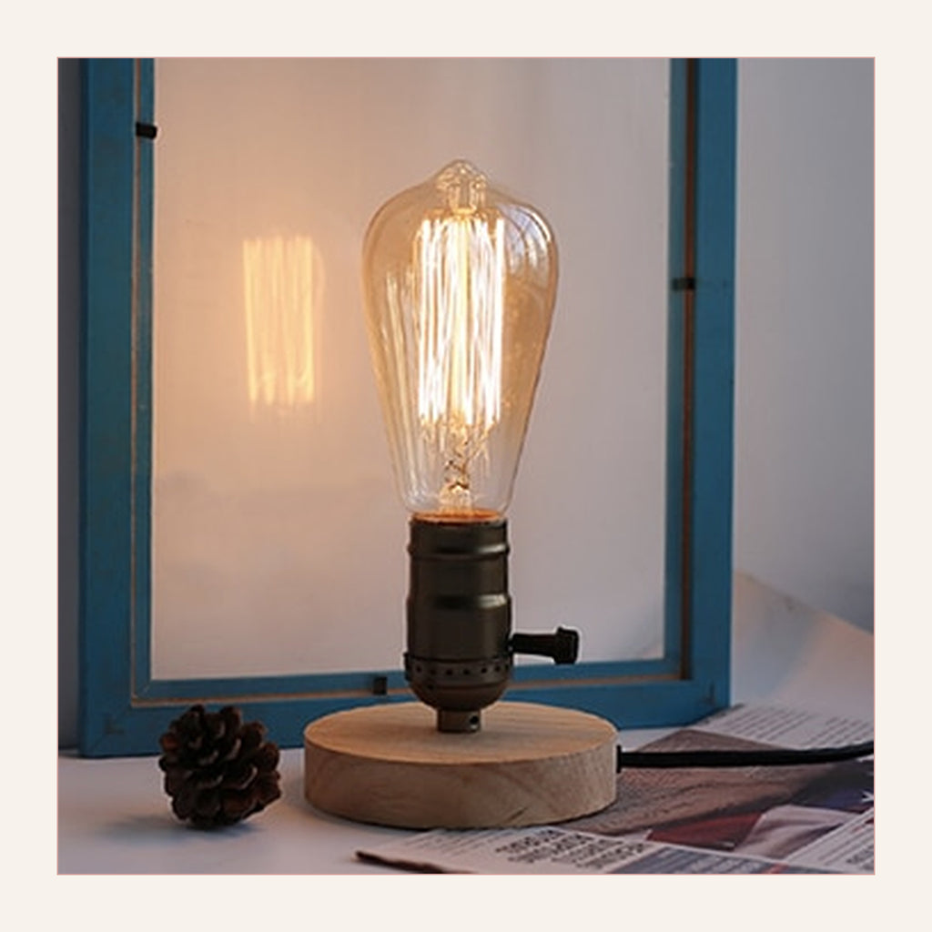 Lampe de table rétro modèle 3 à douille noire et levier latéral, allumée devant une fenêtre