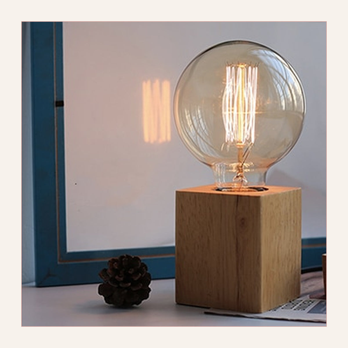 Lampe de table rétro modèle 4 à base cubique, allumée devant une fenêtre