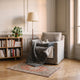 Plaid chauffant gris anthracite 80 x 150 cm replié sur le fauteuil du coin lecture
