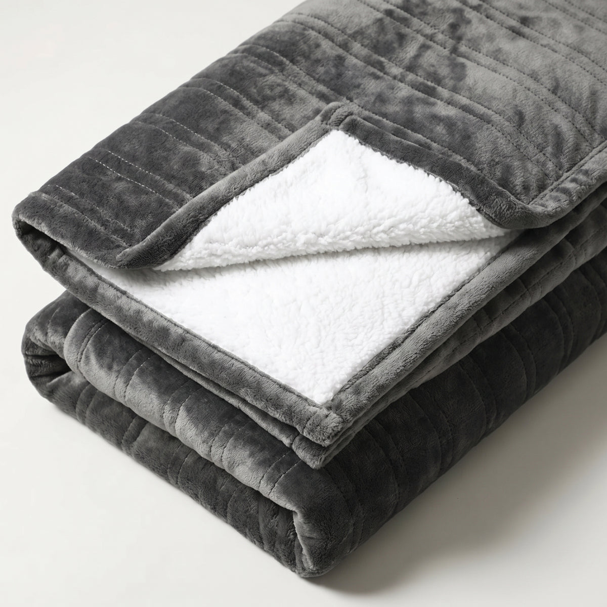 Détail du recto gris anthracite et de l’envers blanc du plaid chauffant