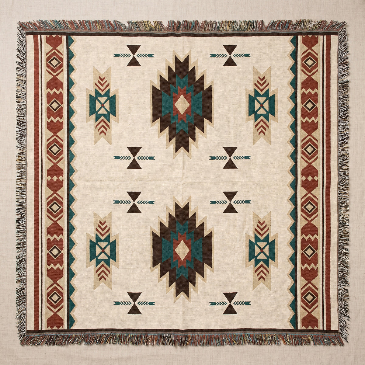 Plaid bohème à motifs géométriques entièrement déployé avec ses franges