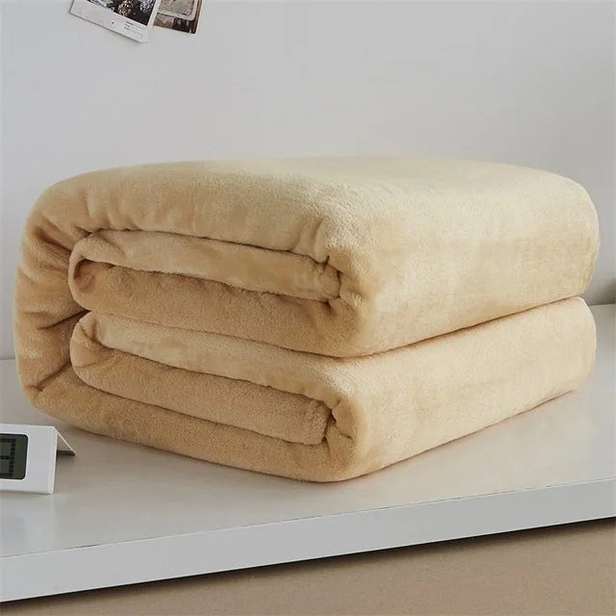 Plaid polaire léger coloris beige plié sur fond clair