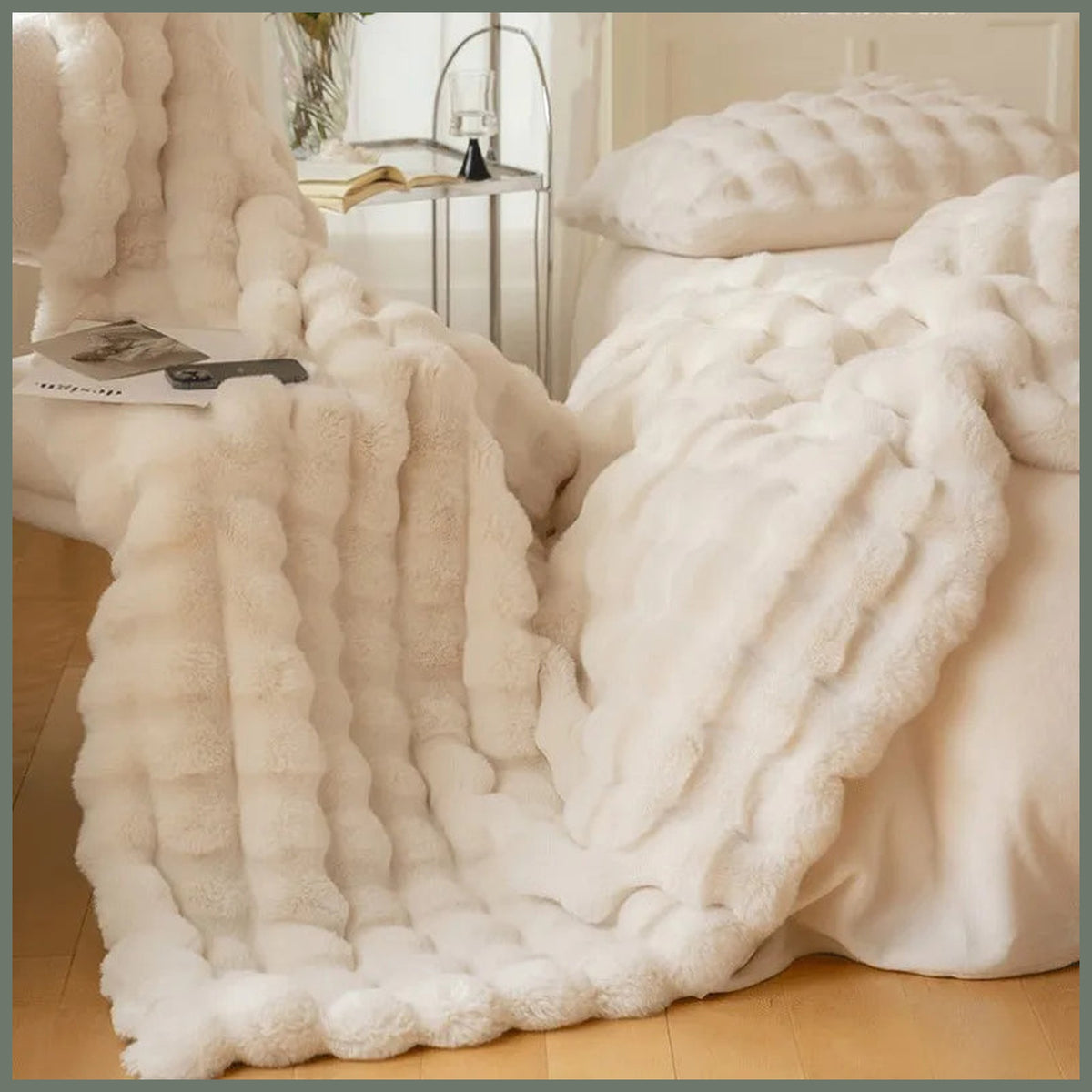 Plaid beige imitation fourrure déployé dans une pièce claire, avec sa retombée et ses rangées en relief visibles Image