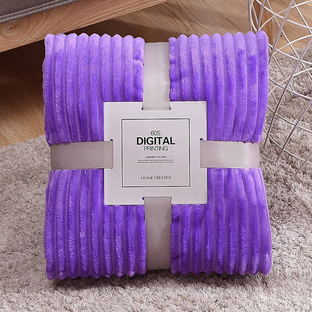 Plaid polaire violet plié, ses côtes en relief et son emballage visibles