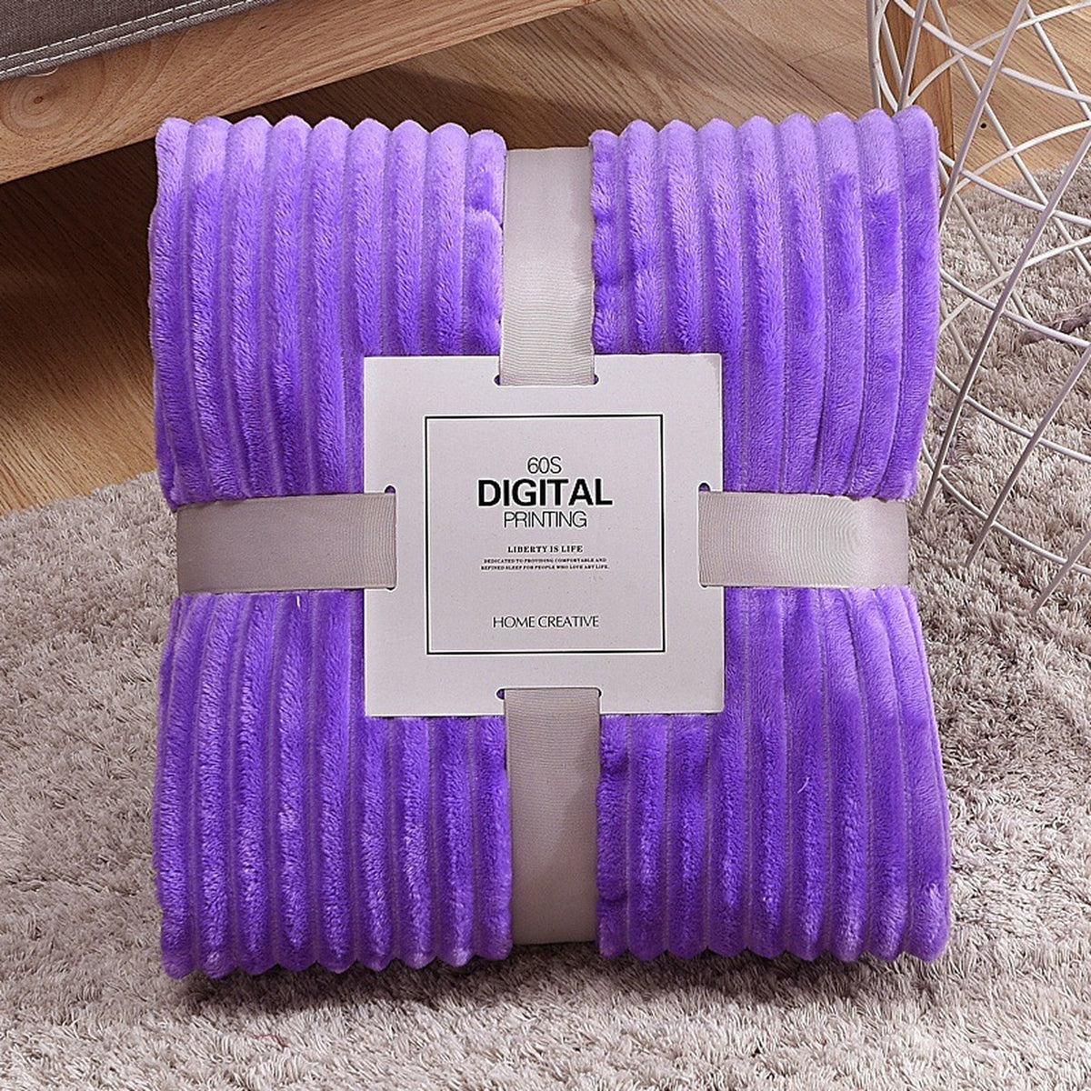 Plaid polaire violet plié, ses côtes en relief et son emballage visibles