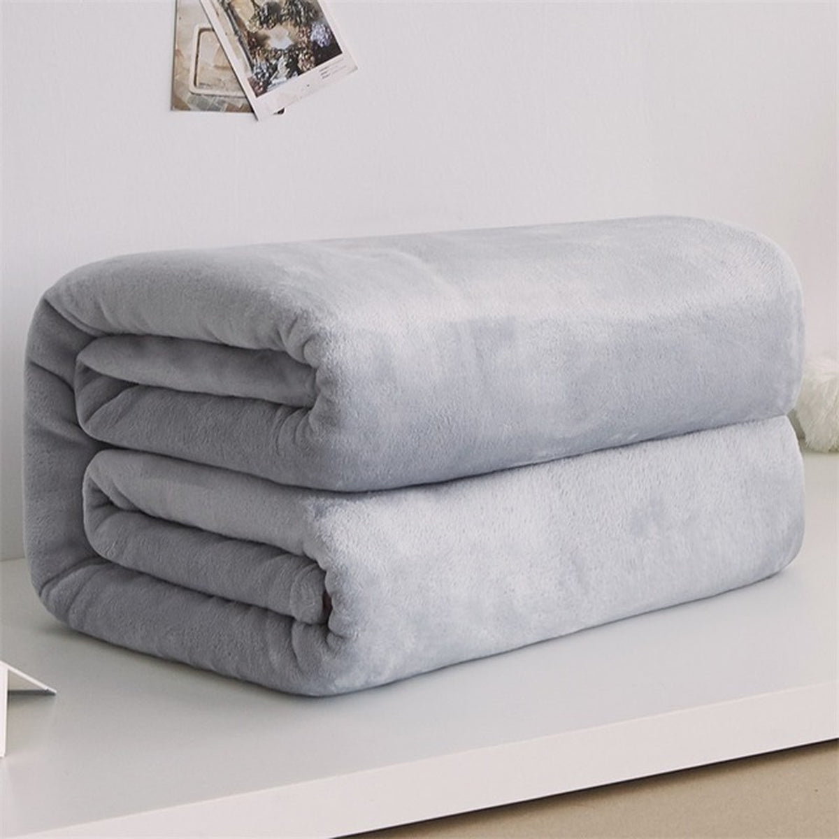 Plaid polaire léger en flanelle coloris gris clair, plié sur fond clair