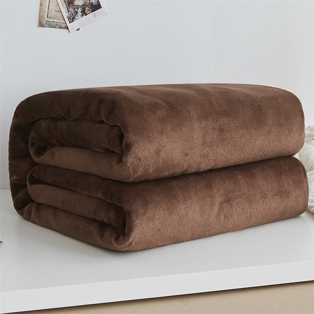 Plaid polaire léger en flanelle coloris marron, plié sur fond clair
