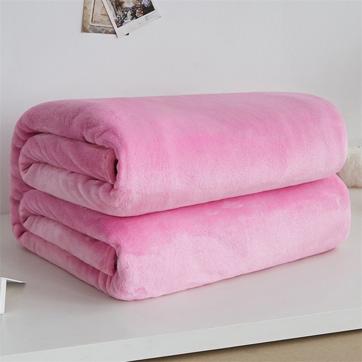 Plaid polaire léger en flanelle coloris rose clair, plié sur fond clair