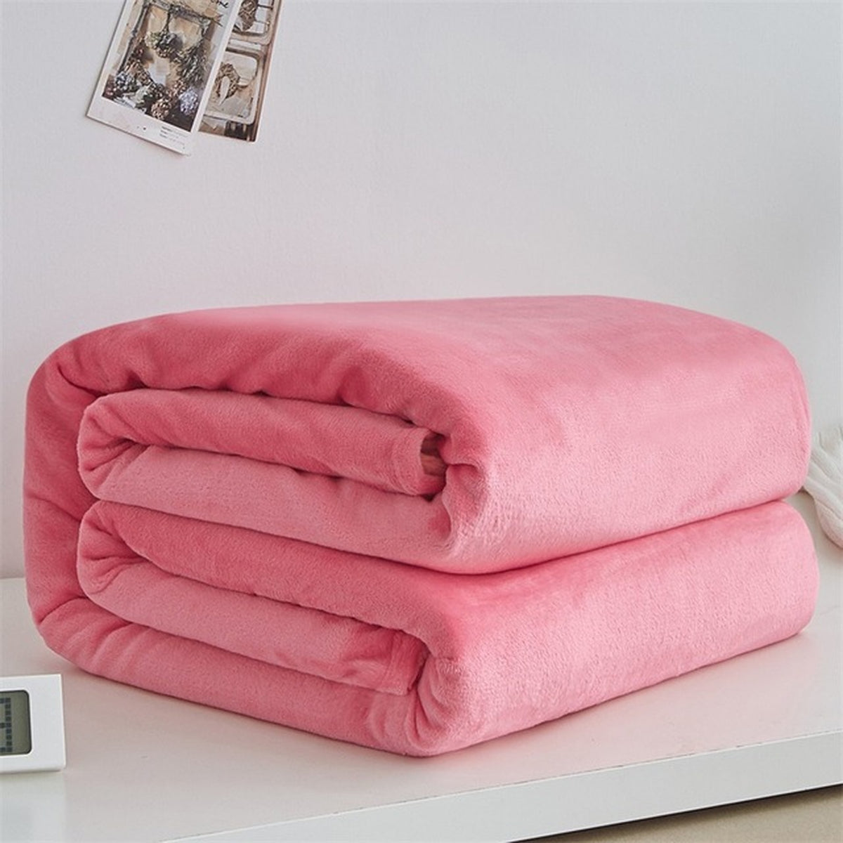 Plaid polaire léger en flanelle coloris rose foncé, plié sur fond clair