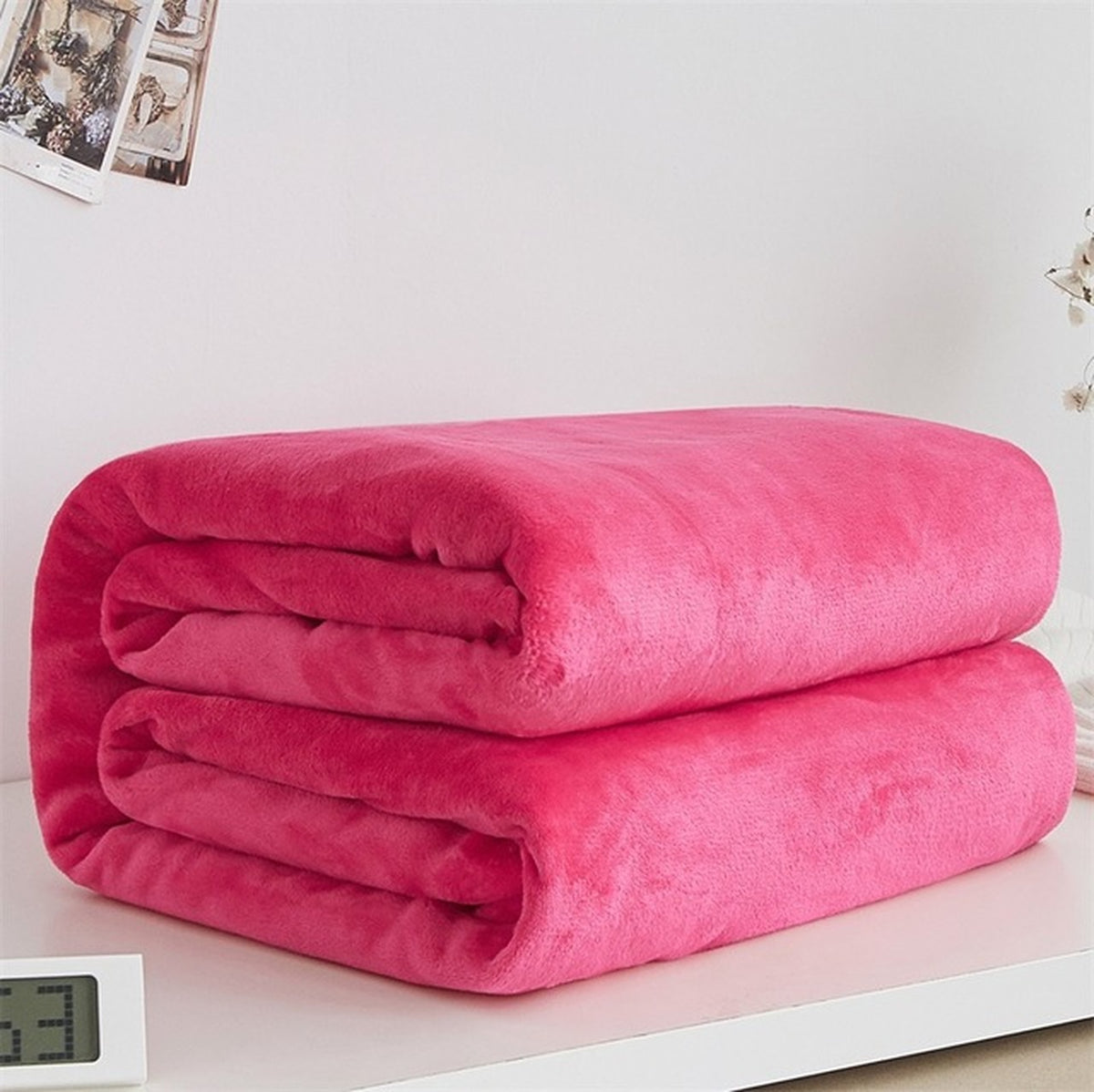 Plaid polaire léger en flanelle coloris rose vif, plié sur fond clair
