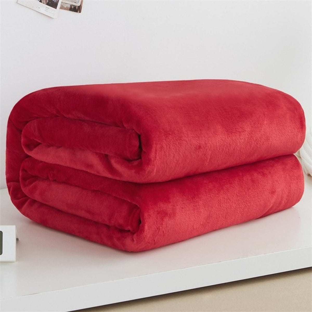 Plaid polaire léger en flanelle coloris rouge clair, plié sur fond clair