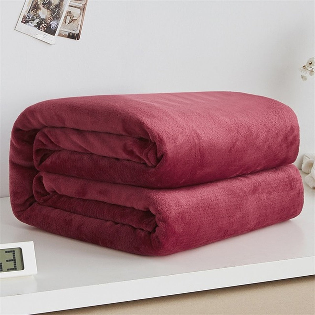 Plaid polaire léger en flanelle coloris rouge foncé, plié sur fond clair